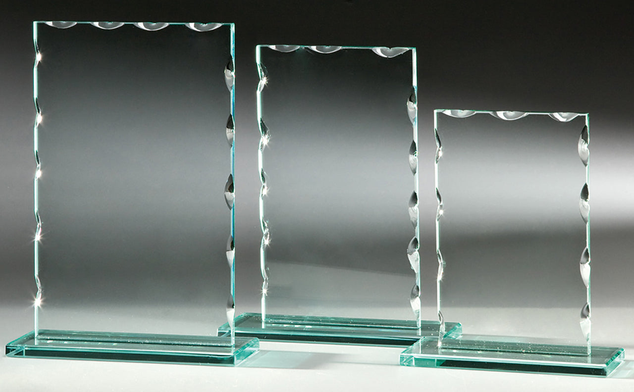 Satz mit Produktname: Drei Glaspokal Nürnberg 3-er Serie 150x120 mm – 198x150 mm PK766633-31-3-E50 Tafeln in unterschiedlichen Größen mit dekorativen Kanten, jeweils mit einem Emblem versehen, stehen auf einer reflektierenden Oberfläche vor einem grauen Hintergrund.