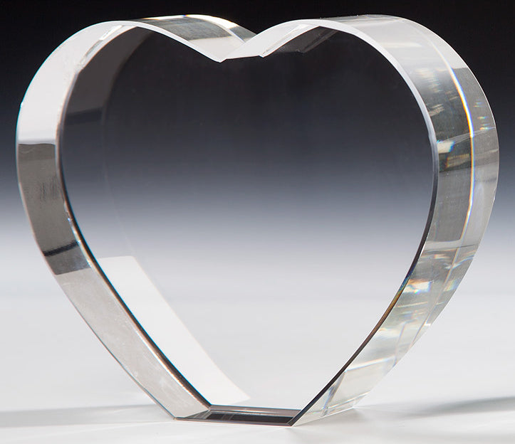 Herzförmiger Award aus klarem Kristallglas mit polierten Kanten, freistehend vor grauem Verlaufshintergrund. Awards Mülheim 3-er Serie von POMEKI.