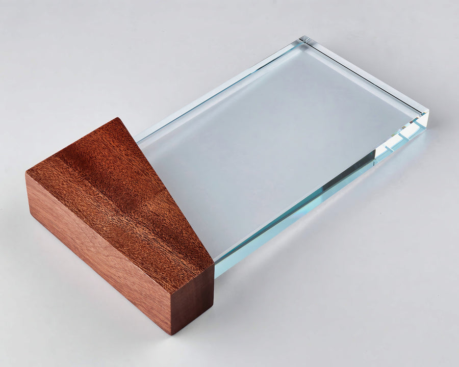 Eine rechteckige Glastrophäe mit einem Holzsockel an einem Ende, fachmännisch mit „Awards Düsseldorf 255 mm PK768184“ graviert, ruht anmutig auf einer weißen Oberfläche.