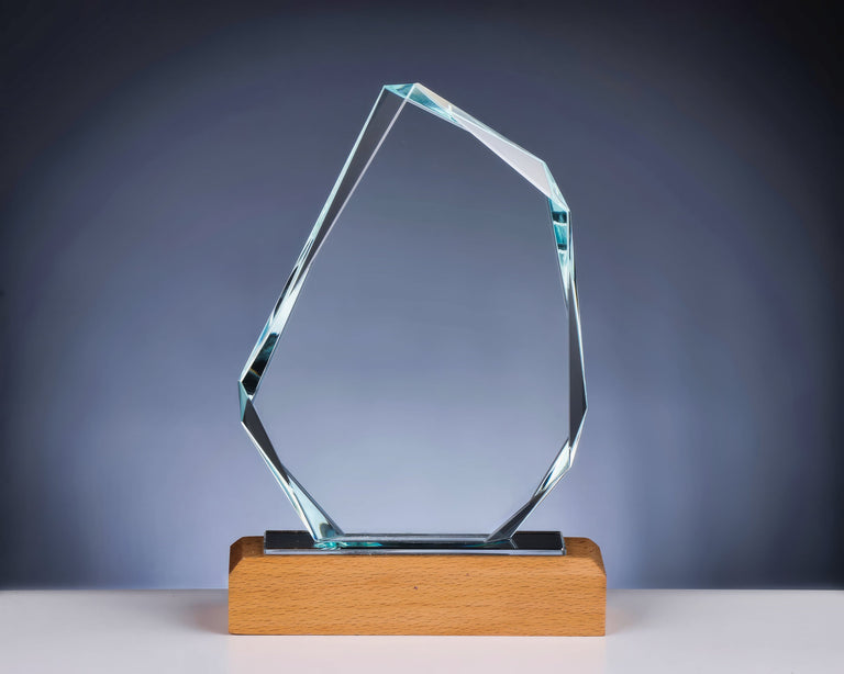 Awards Hamburg 150x230 mm – unregelmäßig geformter transparenter Award auf Sockel in Holzoptik vor blaugrauem Hintergrund