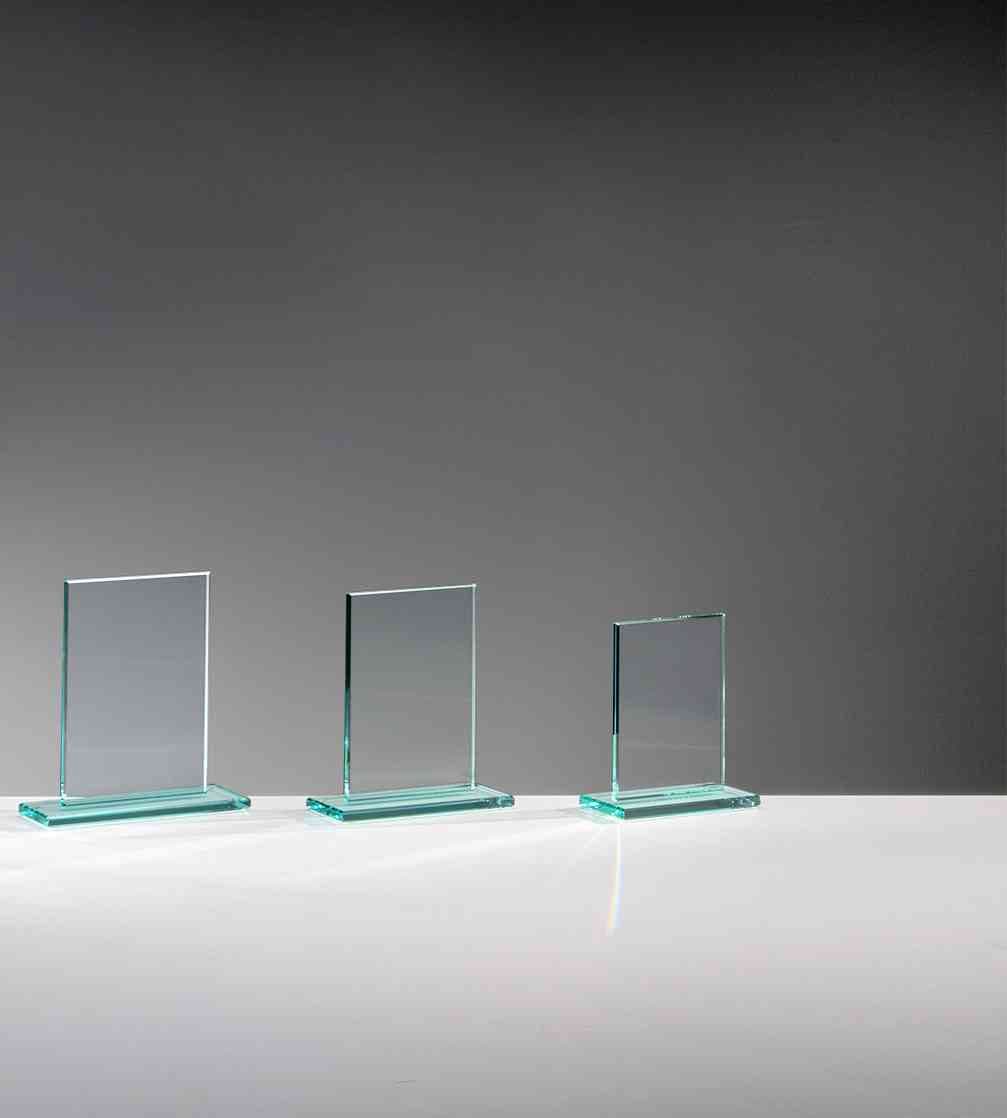 Drei Glaspokal Frankfurt am Main 3er Serie 117x100 mm - 150x140 mm PK735265-60-3-E50 Glasscheiben unterschiedlicher Größe stehen aufrecht auf einer grauen Oberfläche vor einem grau verlaufenden Hintergrund, jeweils verziert mit einem INKLUSIVE-Emblem.