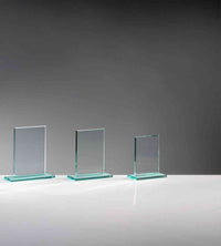 Thumbnail for Drei Glaspokal Frankfurt am Main 3er Serie 117x100 mm - 150x140 mm PK735265-60-3-E50 Glasscheiben unterschiedlicher Größe stehen aufrecht auf einer grauen Oberfläche vor einem grau verlaufenden Hintergrund, jeweils verziert mit einem INKLUSIVE-Emblem.