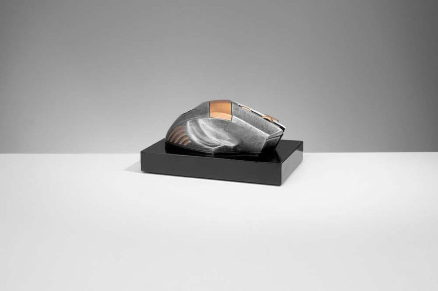 Eine schlanke, metallische Computermaus mit futuristischem Design präsentiert sich als elegante Trophäe Computer Maus 70 mm x 150 mm PK739678-62593-E25 auf einem schwarzen rechteckigen Ständer vor einem einfachen grauen Hintergrund.