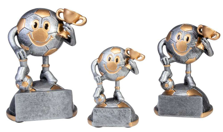 Drei lächelnde Comicfiguren mit Fußballkopf halten einen goldenen Pokal, auf hellen Sockeln. 3-er Serie Fussball Kinder 88 mm - 125 mm von POMEKI.