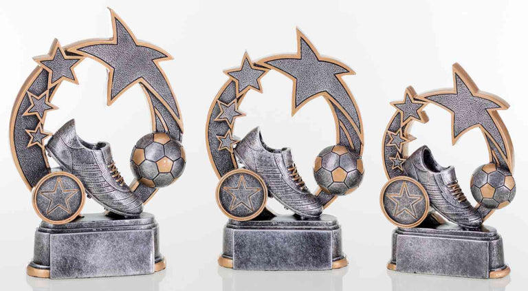 Drei graue Fußballtrophäen mit Sternenmotiven und einem Fußballschuh auf runder Basis, von der größten zur kleinsten angeordnet. 3-er Serie Fußball 127 mm – 160 mm von POMEKI.