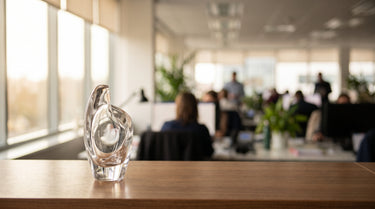 Eleganter gläserner Award auf einem Schreibtisch in einem hellen Büro – KI-generiertes Symbolbild