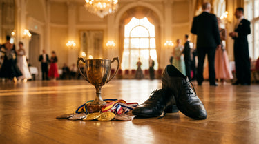 Pokal und Medaillen auf einem Tanzparkett neben einem Paar Tanzschuhe – KI-generiertes Symbolbild