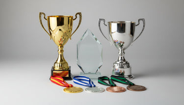 Verschiedene Pokale, Glas-Award und Medaillen für Anlässe in Münster auf neutralem Hintergrund
