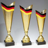Drei goldene Trophäen mit schwarzem Sockel, die oben jeweils mit einem rot-schwarz-gelben Streifen verziert sind. Diese Auszeichnungen im exklusiven Design sind in unterschiedlichen Höhen von links nach rechts angeordnet: die Pokale Fellbach 3-er Pokalserie 367 mm - 460 mm