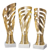 Die Pokale Weinheim 3-er Pokalserie 429 mm - 492 mm zeigt drei goldene Metalltrophäen mit wirbelnden durchbrochenen Motiven auf weißen rechteckigen Sockeln, die sich vor einem schlichten weißen Hintergrund präsentieren.