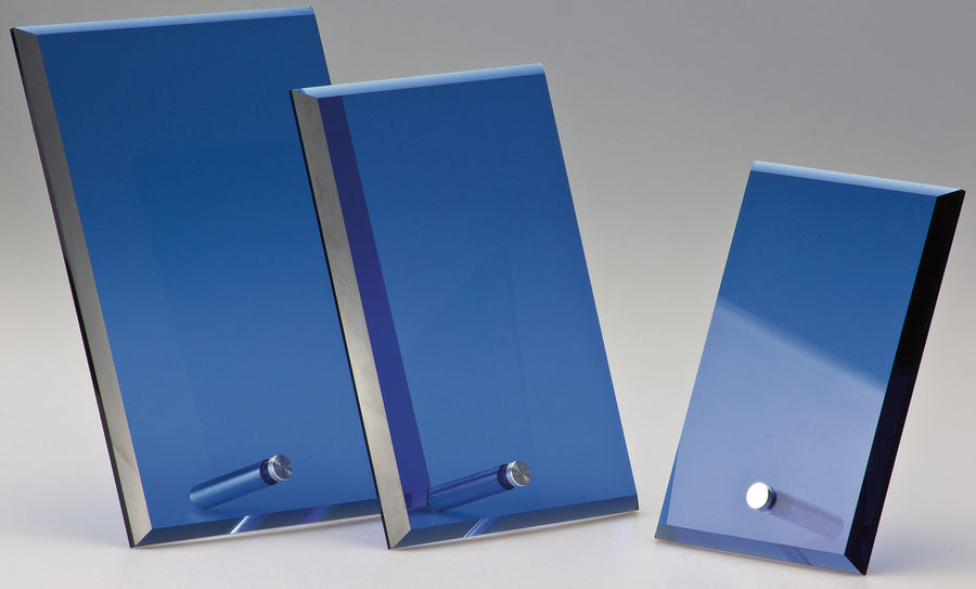 Drei polierte rechteckige Prismen mit blauen Oberflächen in unterschiedlicher Größe sind vertikal auf hellem Hintergrund angeordnet. An der Basis jedes Awards Lübeck 3-er Serie 151x100 mm - 203x150 mm PK766926-24-3 ist ein kleiner Metallzylinder befestigt.