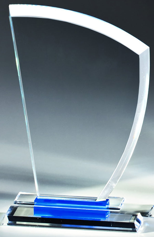 Eine Auszeichnung aus gebogenem Glas mit klarem Sockel und blauem Akzent, präsentiert auf grauem Hintergrund, elegant verpackt in einer Auszeichnung Kassel 3-er Serie 186x116 mm – 226x146 mm PK766950-48-3.