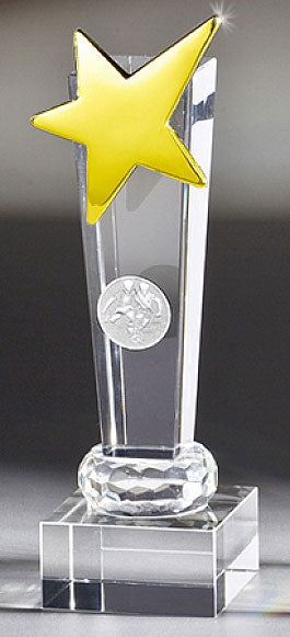 Die Glaspokal Karlsruhe 3-er Serie, von 150 mm bis 190 mm (PK767283-81-3-E25), besteht aus einem Kristallpokal mit einem gelben Stern auf der Oberseite, montiert auf einem quadratischen Sockel aus Kristallglas. Der Preis wird elegant in einer blauen Geschenkbox präsentiert.