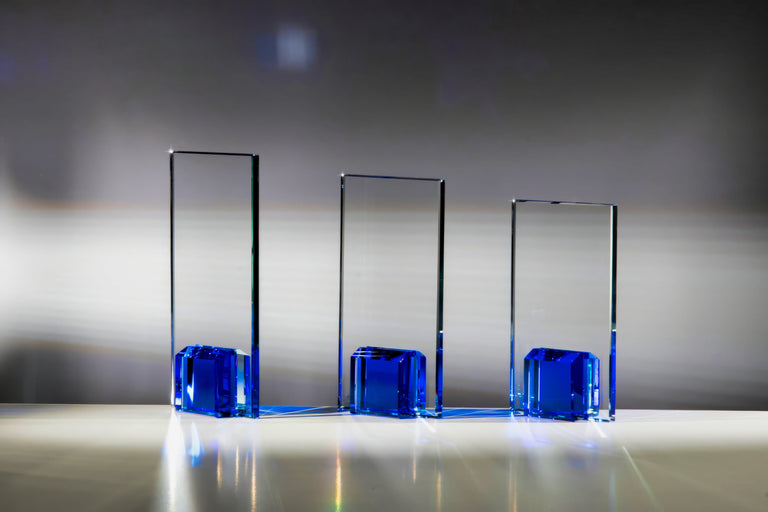 Awards Nürnberg, 3er-Serie – drei hohe transparente Awards mit blauem Würfelsockel in gestaffelten Größen