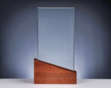 Thumbnail for Transparente, rechteckige Glastafel ohne Gravur auf einem schräg geschnittenen Holzsockel vor blaugrauem Hintergrund. Awards Düsseldorf 255 mm von POMEKI.