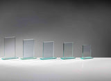 Fünf klare Glasplatten in absteigender Größe auf grünlichen Glassockeln, ohne Gravur, vor grauem Hintergrund. Glaspokal Hamburg 5-er Serie von POMEKI.