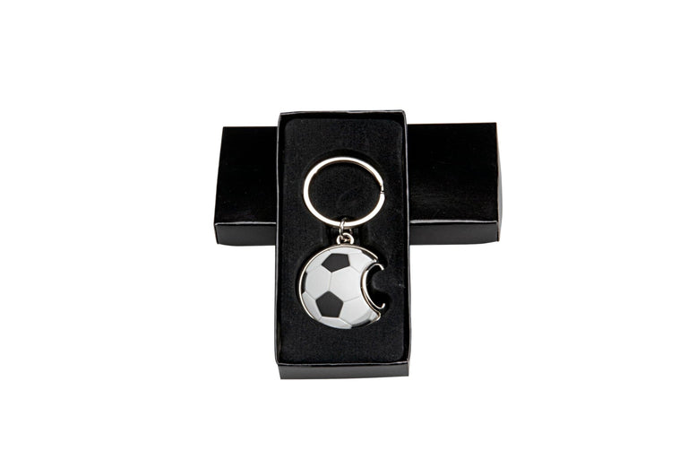 Schlüsselanhänger mit schwarz-weißem Fußball und halbmondförmigem Ausschnitt, in einer offenen schwarzen Geschenkbox. Schlüsselanhänger Fussball von POMEKI.
