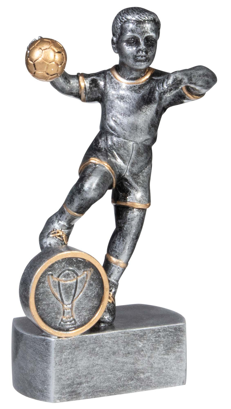 Silberfarbene Figur eines Kindes beim Handballwurf mit goldenem Ball, rundes Pokal-Emblem am Sockel. Trophäe Handball Kind 130 mm von POMEKI.