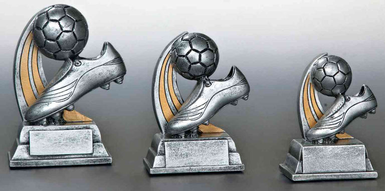 Drei silberne Trophäen in unterschiedlichen Größen mit Fußballschuh- und Balldesign, jeweils mit Holz akzentuiert. 3-er Serie Fußball 100 mm – 130 mm von POMEKI.