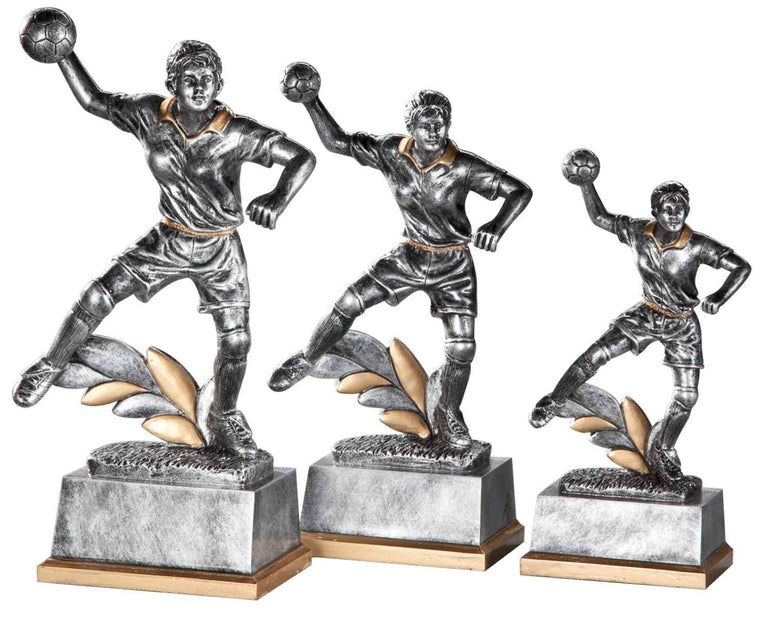 Ein Satz von drei Trophäen für Handballerinnen (190-250 mm), jede zeigt eine Sportlerin in Aktion auf einem rechteckigen Sockel mit Gold- und Silberblattdetails, in einem exklusiven Design-Modell