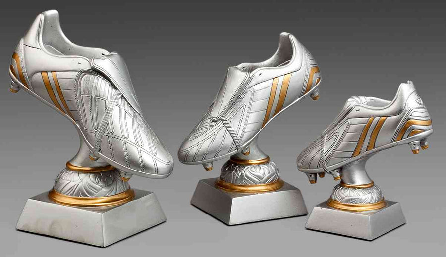 Drei silberne Trophäen in Form von Fußballschuhen sind auf Sockeln mit goldenen Akzenten montiert und in unterschiedlichen Größen angeordnet. Dieses exklusive Design ist perfekt für jede Auszeichnungszeremonie. Diese 3-er Serie Fußball 140 mm - 200 mm PK738700-698-3 ist ideal, um außergewöhnliche Talente und Leistungen anzuerkennen.