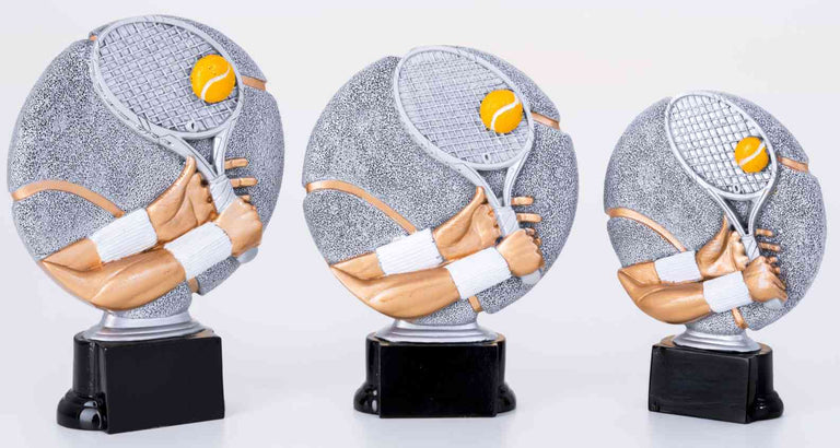 Drei 3-er Serie Tennis 160 mm - 200 mm zeigen eine Hand, die einen Tennisschläger mit Ball hält, montiert auf schwarzen Sockeln. Die Trophäen sind in den Farben Grau, Weiß und Gold gehalten.