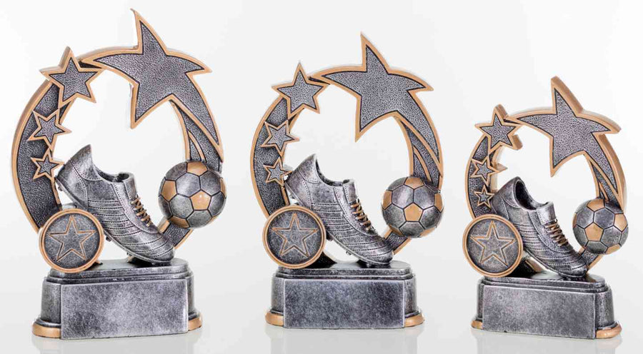 Drei graue Fußballtrophäen mit Sternenmotiven und einem Fußballschuh auf runder Basis, in der Reihenfolge von der größten zur kleinsten Größe angeordnet, verfügen über ein exklusives Design. Der Produktname lautet 3-er Serie Fußball 127 mm - 160 mm PK739410-08-3.