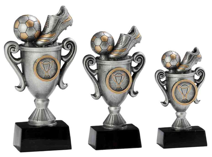 Drei Trophäen aus der Kollektion 3-er Serie Fußball 115 mm – 170 mm PK739493-91-3-E25, jeweils mit einem silbernen Fußball- und Schuhdesign auf schwarzem Sockel, aus hochwertigen Materialien gefertigt und in unterschiedlichen Größen von links nach rechts angeordnet.