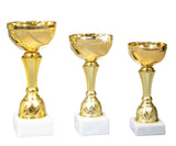 Drei goldene Pokale unterschiedlicher Höhe auf weißen Sockeln vor weißem Hintergrund. Pokale Minden 3-er Pokalserie 157 mm – 200 mm von POMEKI.