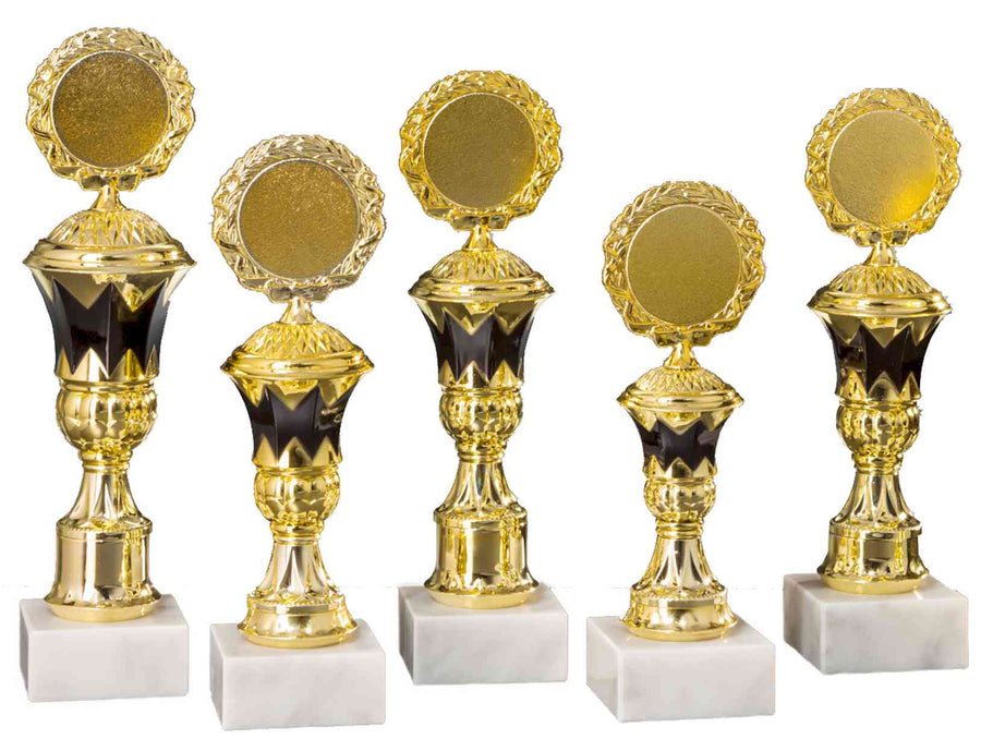 Fünf goldene Pokale Landau, 5-er Pokalserie 197 mm – 246 mm, PK754610-5-E50, mit schwarzen Akzenten und runden leeren Medaillons oben, auf weißen Marmorsockeln stehend.