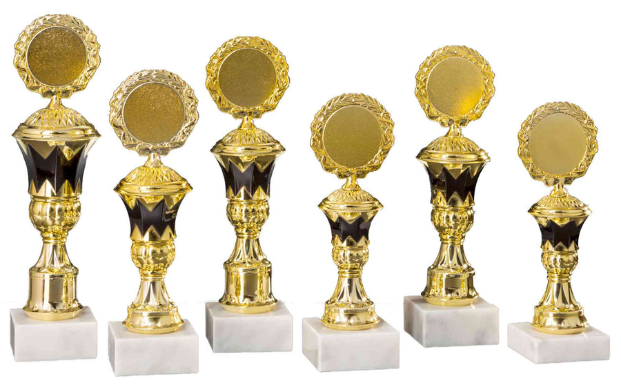 Sechs Pokale Hennef 6-er Pokalserie 197 mm - 265 mm PK754610-6-E50 mit dunklem Sockel und weißem Marmorständer, in exklusivem Design und aus hochwertigem Material gefertigt, sind in einer Reihe angeordnet.