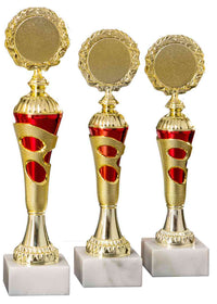 Thumbnail for Drei goldene und rote Pokale Lörrach 3-er Pokalserie 255 mm – 290 mm PK754720-3-E50 mit verzierten runden Spitzen auf weißen Marmorsockeln, isoliert auf weißem Hintergrund.