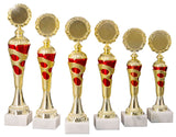 Eine Reihe von sechs goldfarbenen Trophäen mit roten Akzenten auf weißen Sockeln wird nebeneinander vor einem weißen Hintergrund präsentiert und zeigt einen Pokal Goslar 6-er Pokalserie 255 mm – 334 mm mit exquisitem Design.