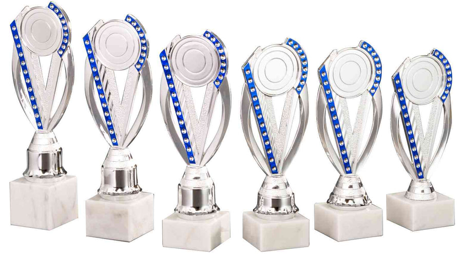 Sechs silberne Pokale Bergheim 6-er Pokalserie 195 mm - 251 mm PK754760-6-E50 mit blauen Akzenten in einer Reihe angeordnet, jeweils auf einem weißen Marmorsockel, mit exklusivem Design.