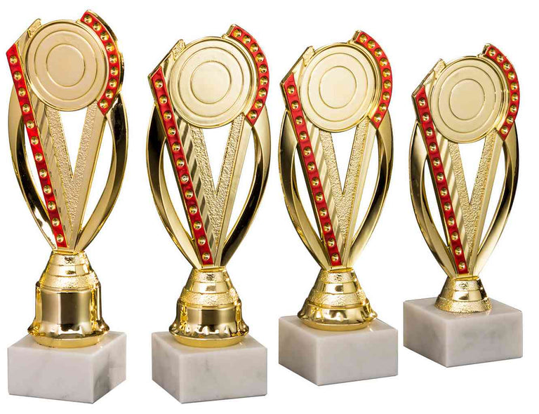 Vier goldene Trophäen mit roten Akzenten sind in einer Reihe ausgestellt, jede auf einem weißen Marmorsockel montiert – die perfekte Pokale Görlitz 4-er Pokalserie 195 mm - 231 mm für jede Leistung.